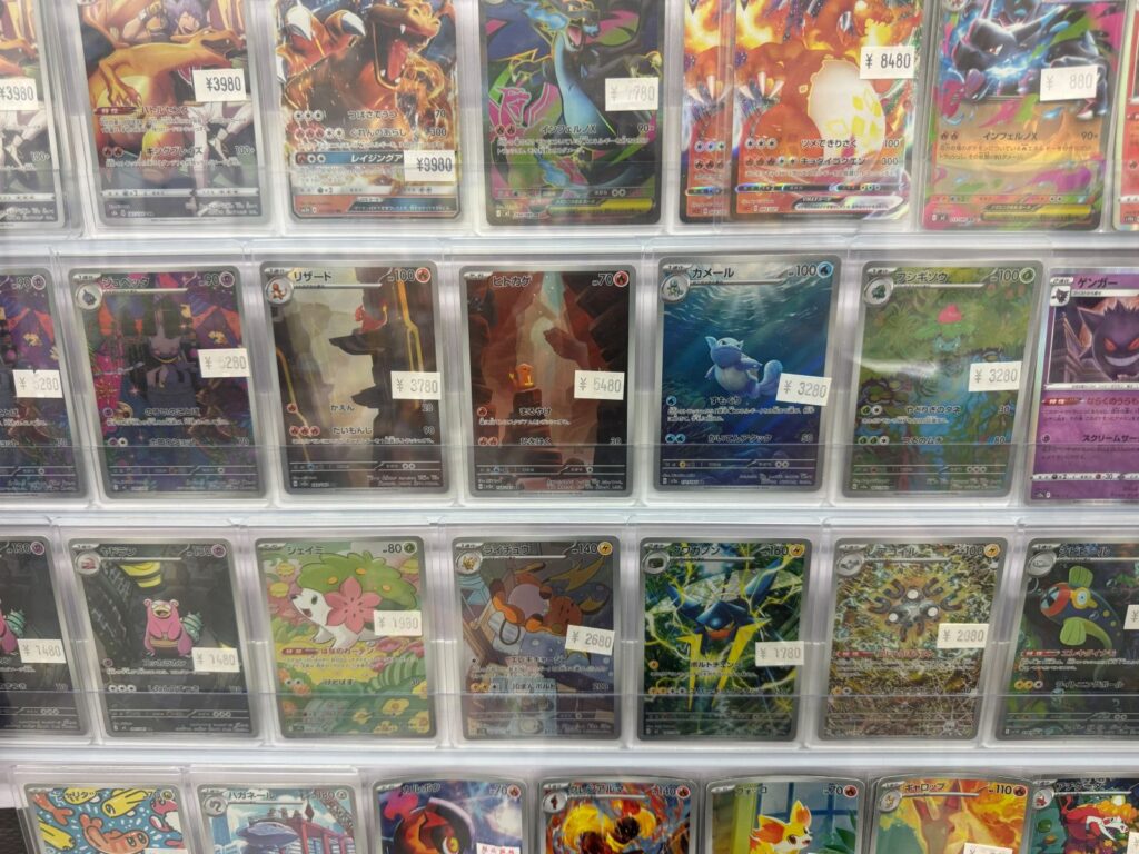 Carte Pokemon singole in bustine protettive con il prezzo scritto sopra