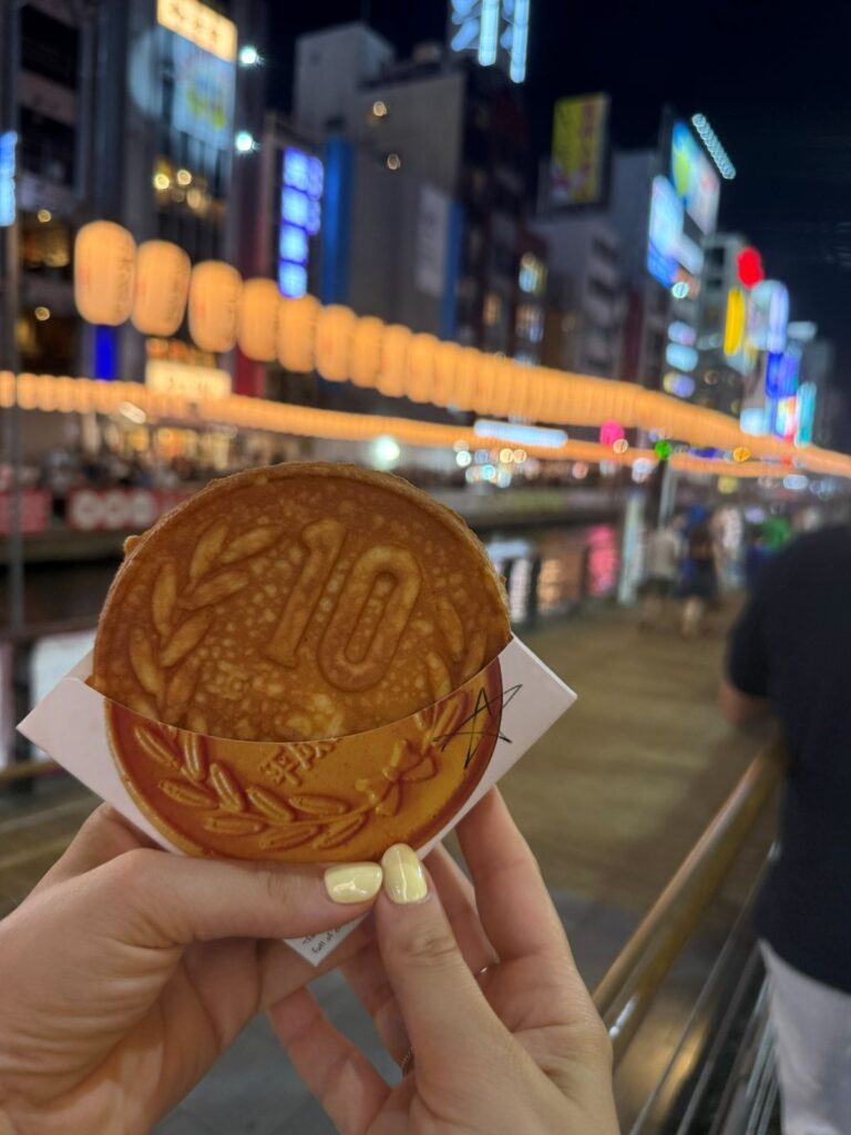 Un dolce a forma di moneta da dieci yen mangiato lungo il canale Dōtonbori