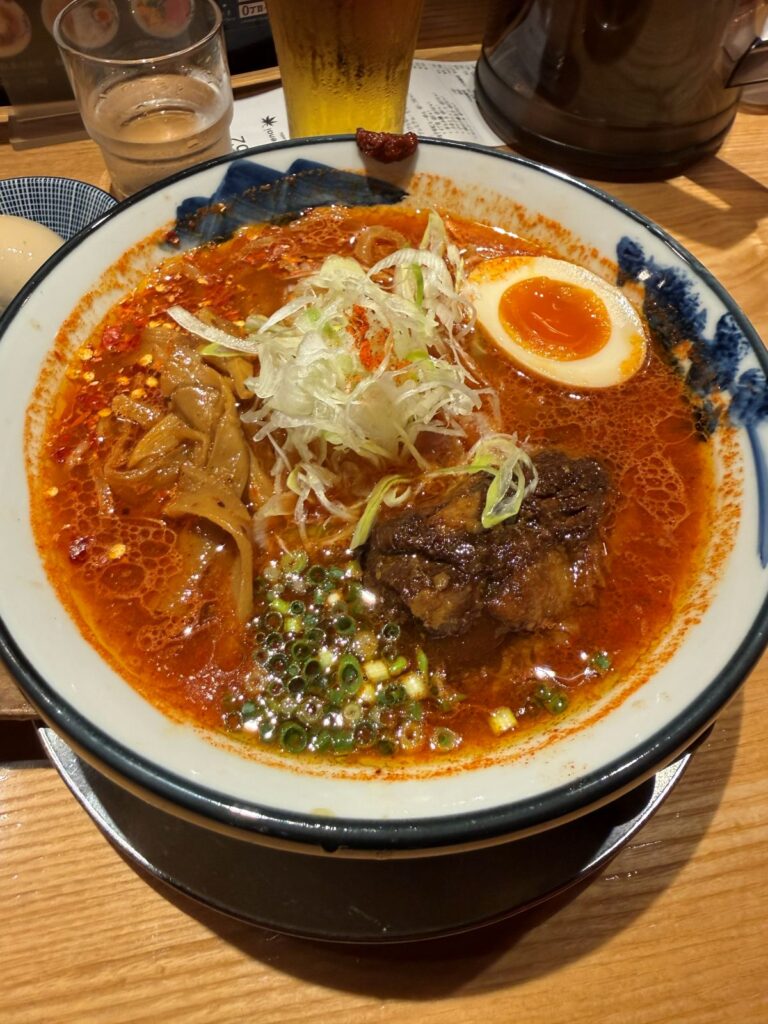 Una ciotola di ramen piccante con uovo marinato, porro e maiale