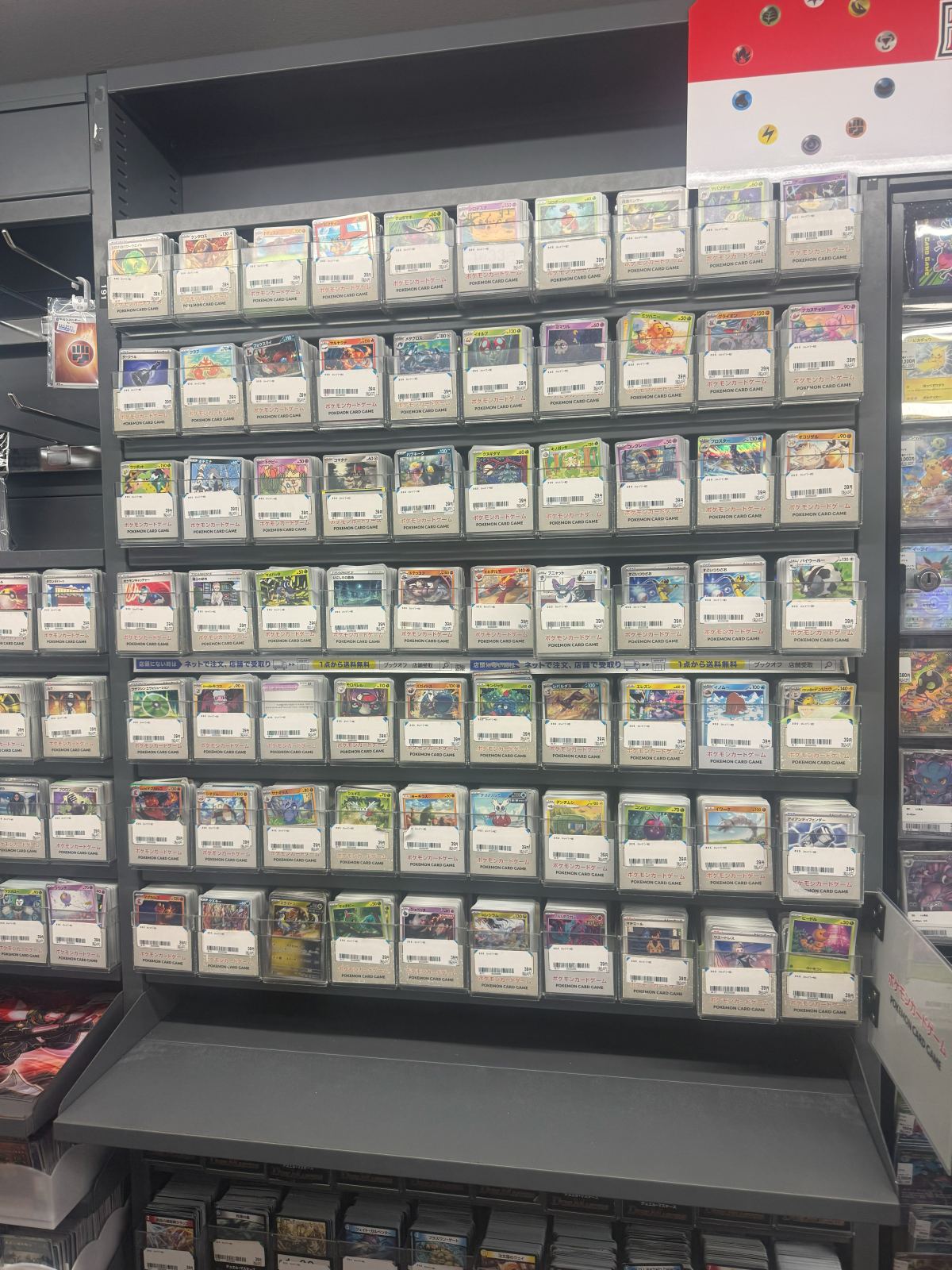 Uno scaffale pieno di bustine di carte Pokemon divise per set