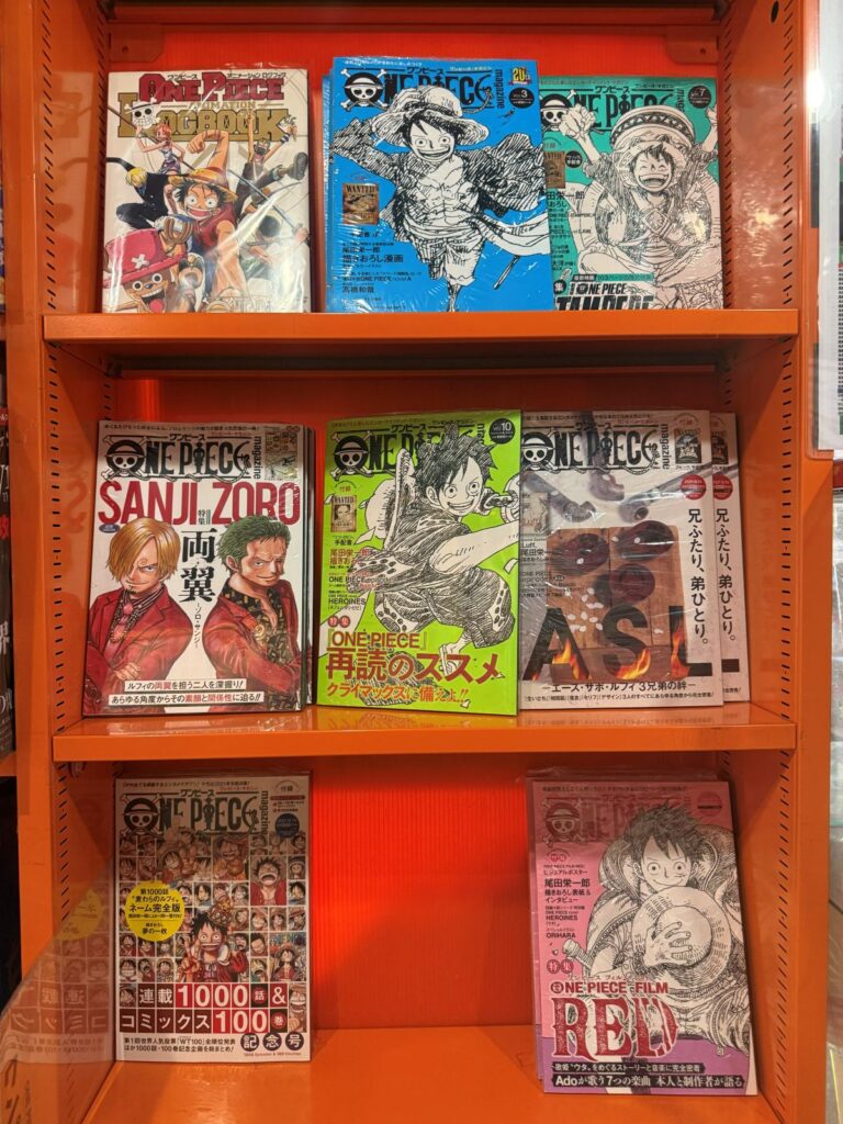 Scaffali con volumi e artbook di One Piece in un negozio di Akihabara