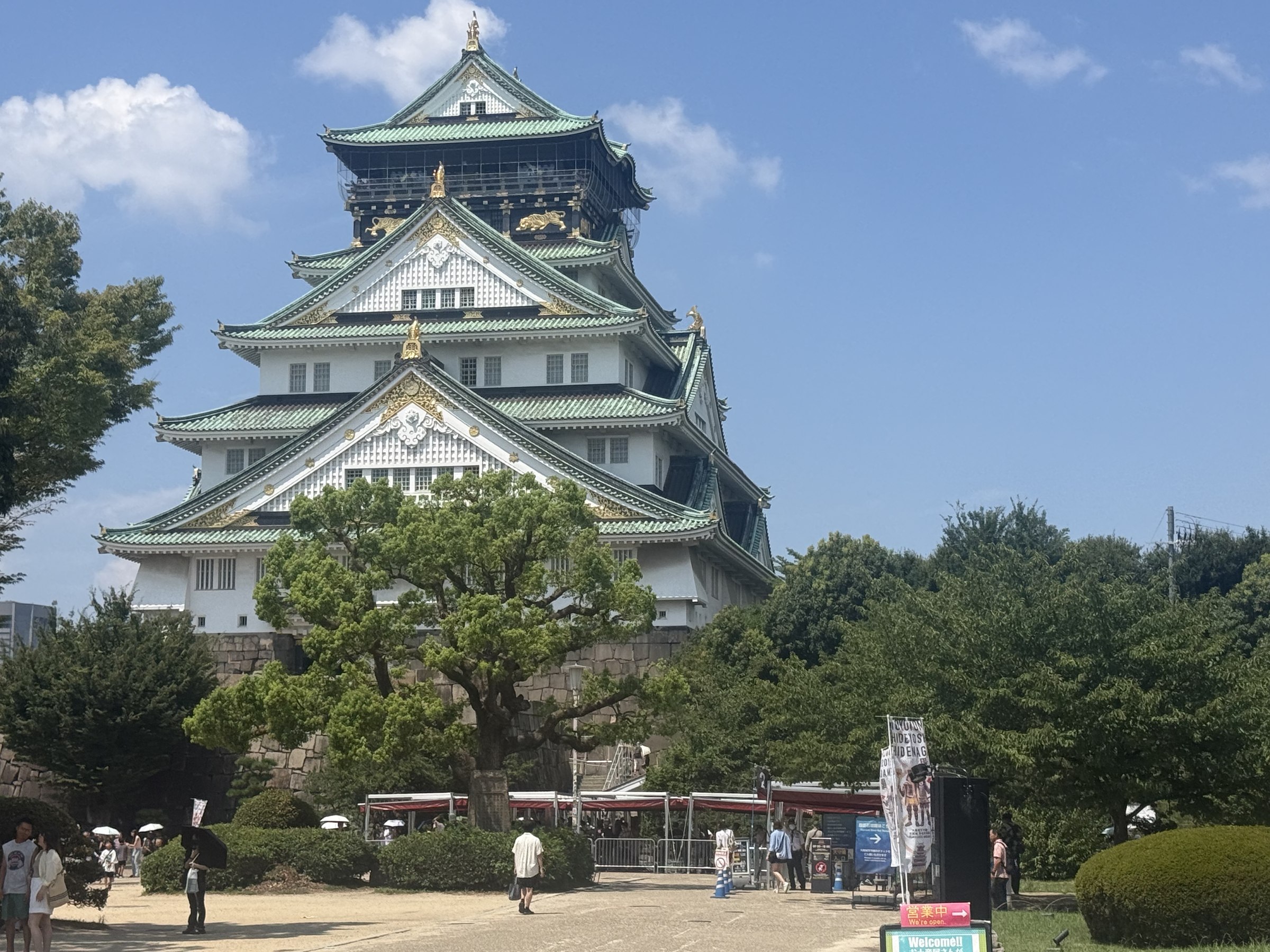 Facciata del Castello di Osaka tra gli alberi