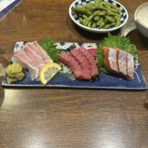 Tris di sashimi con edamame su un tavolo di izakaya in Giappone