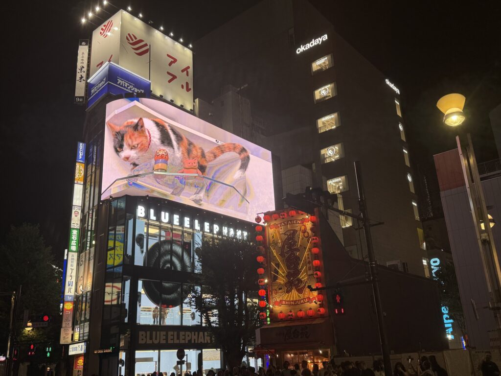 Cartelloni pubblicitari illuminati a Shinjuku Sanchome di notte