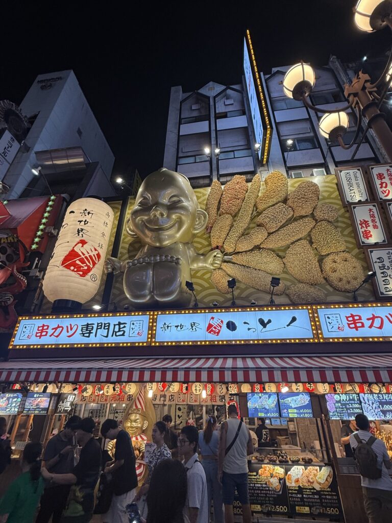 Insegna con la mascotte del ristorante Kushikatsu Daruma a Dotonbori