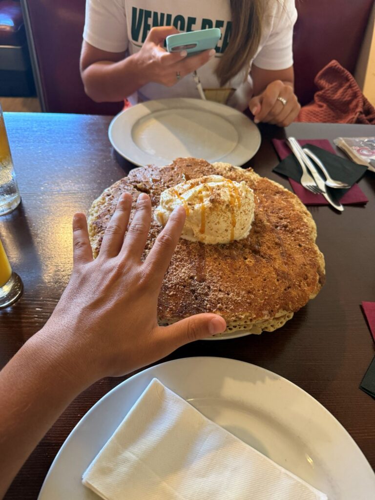 Un enorme pancake con panna servito al tavolo di un diner americano
