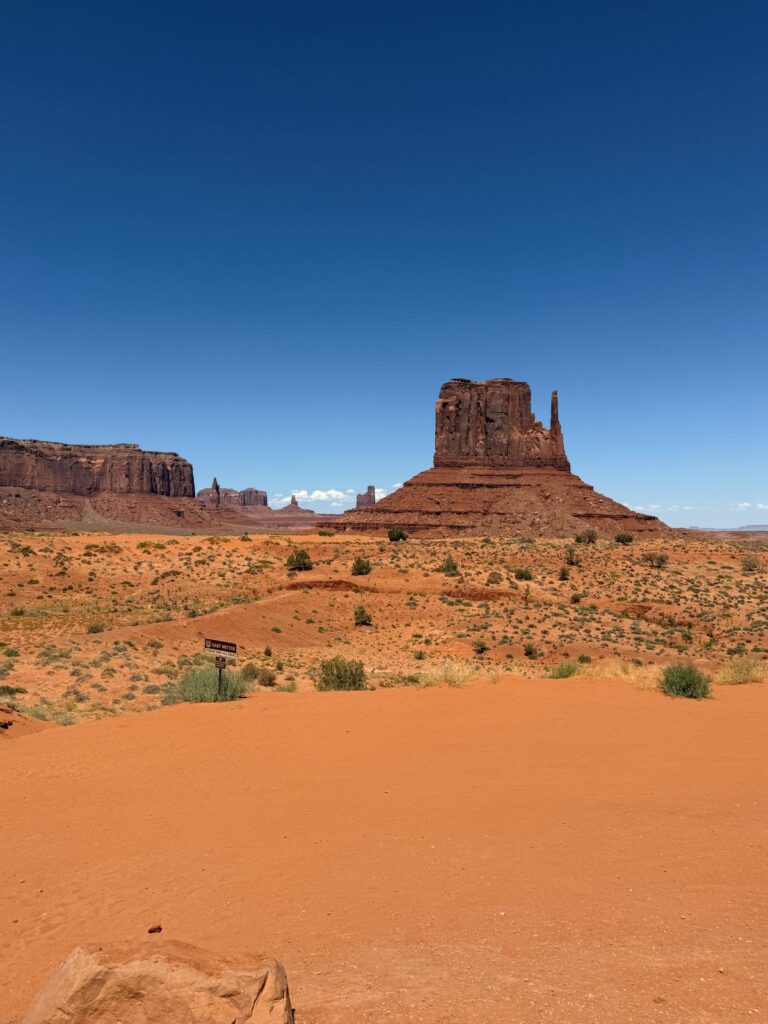 West Mitten Butte con la sabbia rossa in primo piano